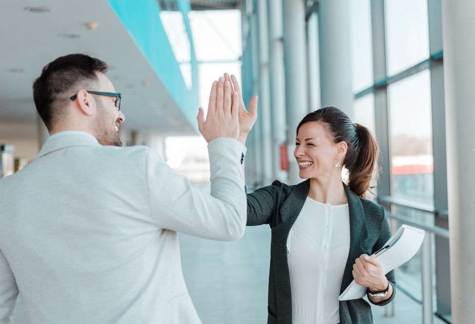 co-workers high-five each other