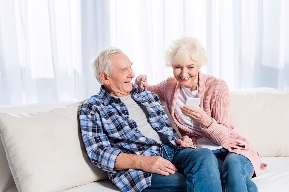 Senior couple sitting on the sofa sharing mobile