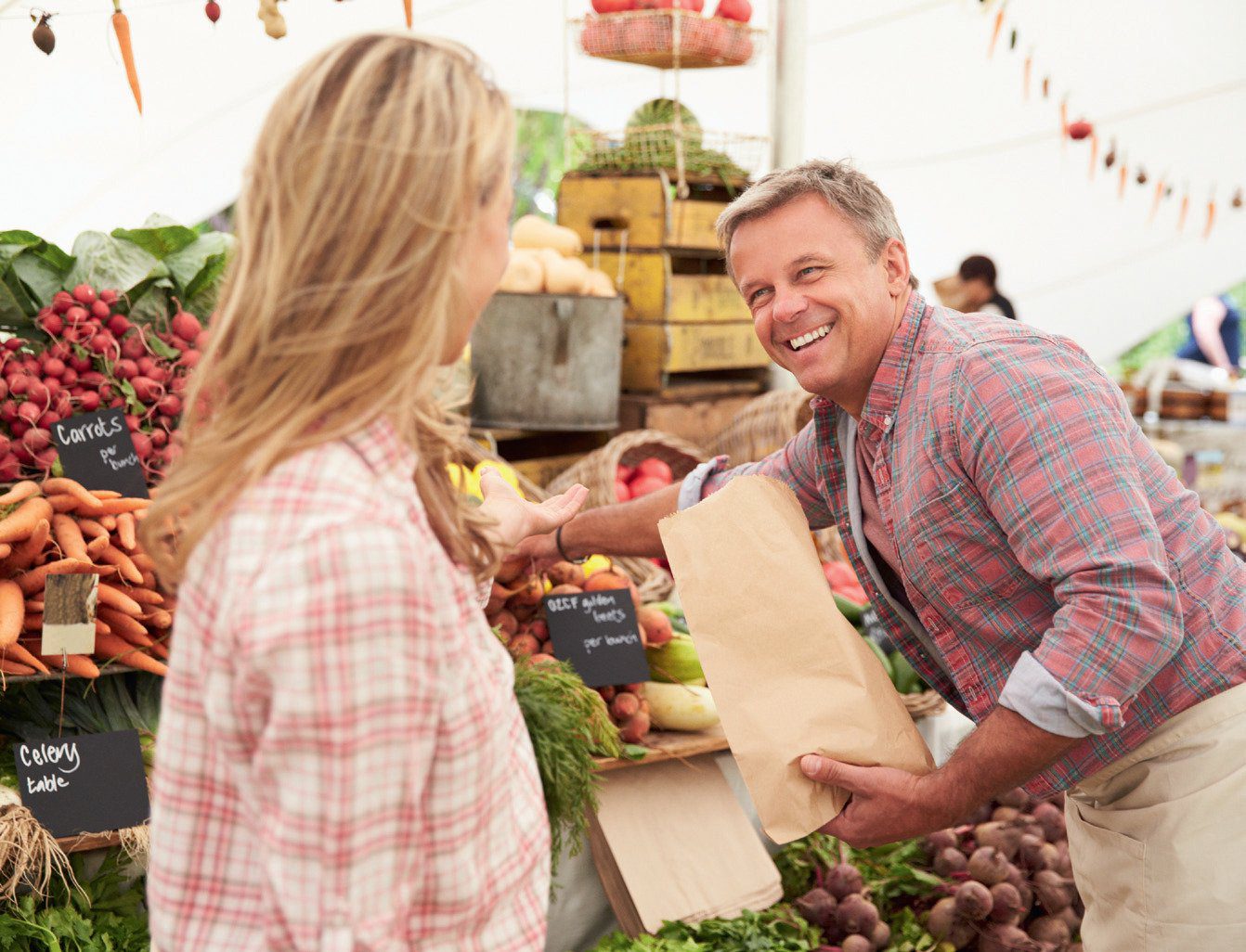 man and woman buying organic food at the market